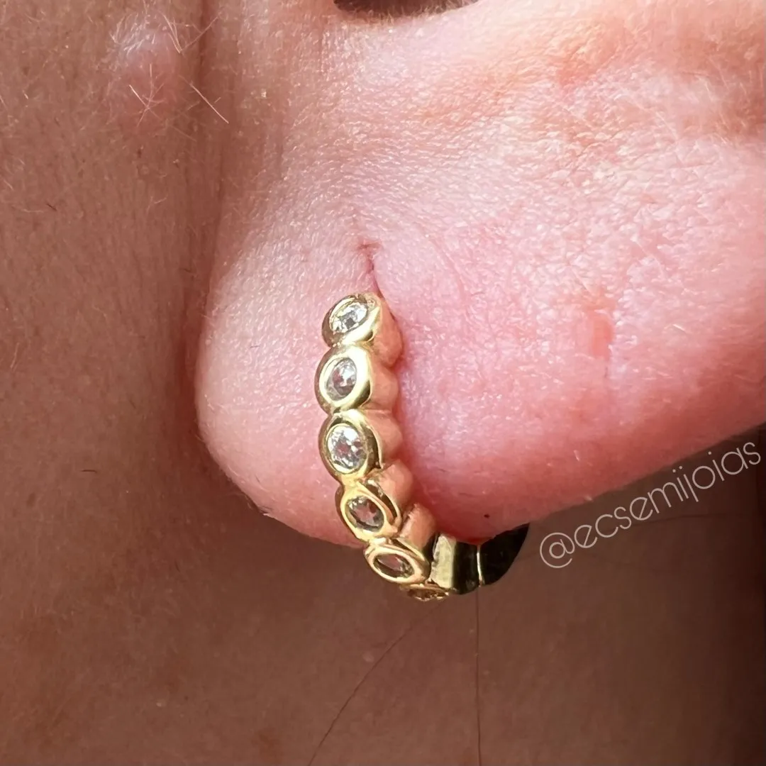 Argola tranqueta com 1 fileira cravejada com bordas em cada zircônia - 12mm - banhado a ouro 18k